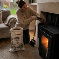 Pouring COFFUEL pellets into a pellet stove hopper